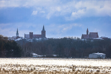 Winter panorama of historic town with churches and snow-covered fields