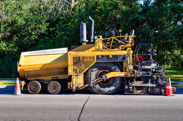 side view of a road paving machine parked on a street,