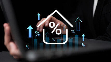 A business professional engages with a laptop, analyzing real estate trends represented by upward...
