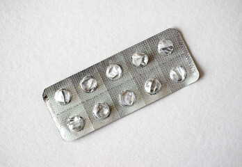 Empty blister pack with foil peeled back, revealing cavities pills used to be. Medicine pills close-up, pharmaceutical, foil, drugs.