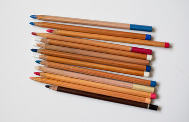 Soft pastel pencils isolated on white, top view. Multicolored pencils. Art supplies for drawing and graphics.