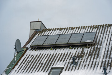 Obraz premium Snow covered solar panels on residential roof during winter conditions