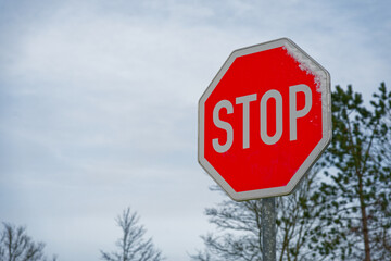 Obraz premium Red stop sign covered with snow during winter storm Elli January 2026