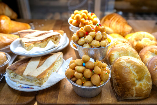 Neapolitan pastiera slices and struffoli cups in a bakery display