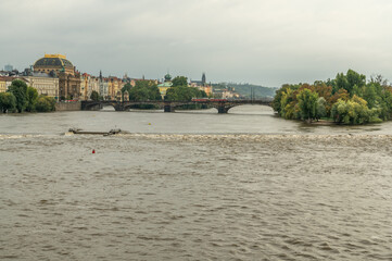 PRAGUE, CZECH REPUBLIC - SEPTEMBER 15, 2024: High water level of the Vltava river during the floods in the historic center. Swollen river with muddy water flowing past Prague Castle and Charles Bridge