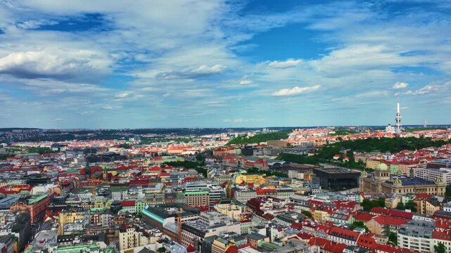 Prague city across red rooftops. Prague urban pattern from above. Prague historic districts with modern landmarks. Prague capital of Czech.