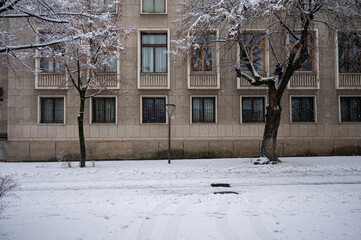 Snow covered street and residential building facade in winter