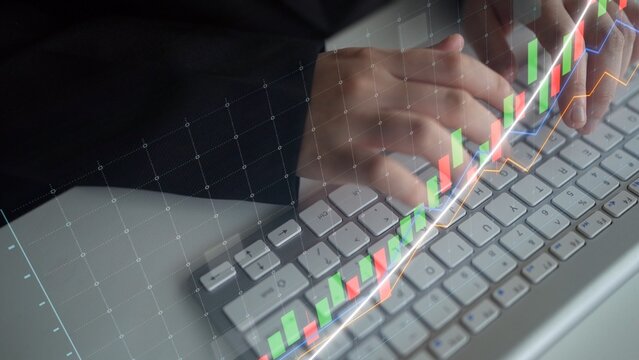 A business professional analyzes financial data with stock market graphs displayed over a computer keyboard, capturing the essence of data-driven decision-making. Copula - Powered by Adobe