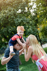 Happy family is playing cheerfully in the park in the summer.