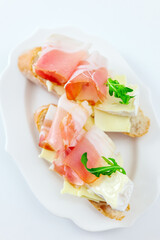 Delicious sandwich with ham and cheese on white plate