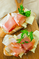 Fresh meat and cheese on wooden board