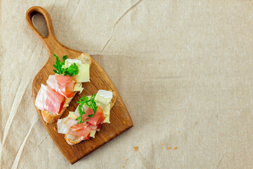 Bruschetta with ham and cheese on a wooden board