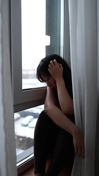 Young woman feeling sad and pensive, pondering loneliness and mental health challenges during a melancholic season.