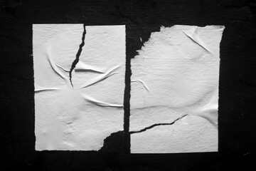 two white torn posters with folds and no inscriptions