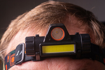A close-up of a headlamp on a man's head