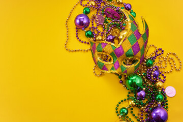 Fototapeta premium Mardi gras mask and beads on yellow background