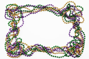 Mardi gras beads forming an oval frame on white background