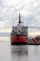Fototapeta premium Prescott, Canada - April 6, 2025: Canadian coast guard vessel Griffon docked at pier. Ship with Canadian flag on river.