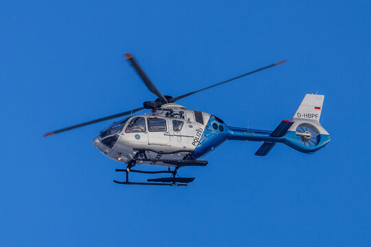 Ein Polizeihubschrauber vom Typ Airbus H135 mit dem Kennzeichen D-HBPF fliegt &uuml;ber dem Gebiet des Flughafens M&uuml;nchen. Die Maschine geh&ouml;rt zur Hubschrauberstaffel der Bayerischen Polizei, 