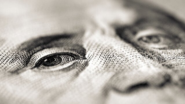 Detail of Benjamin Franklin's face on a US $100 bill. Franklin was one of the Founding Fathers of the United States, editor and signatory of the Declaration of Independence, and first Postmaster