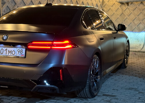 Black matte BMW 5-Series 540 d G60 xDrive on street lot. Exterior BMW 540d G60, premium german car, luxury sedan manufactured by the German automobile manufacturer BMW. Wrapping car. 