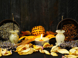 Dried herbs, flowers, pomander, scented candles, and incense sticks placed on a black background. Ingredients for air freshening and relaxation.
 