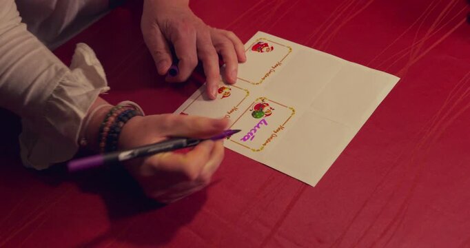 A white card with a red border sits on a red bedspread