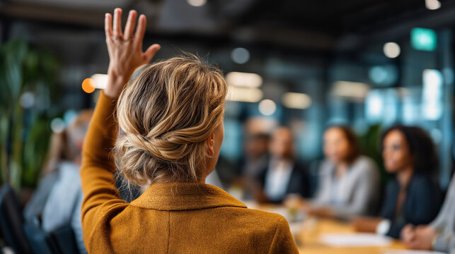 Faceless woman raising hand in corporate meeting with audience, participation gesture, professional engagement scene, with copy space