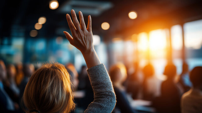 Faceless audience member raising hand during conference Q&A in bright room, participation gesture, question asking moment, with copy space