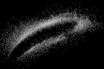 Sweet granulated sugar isolated on a black background, top view. Spilling white sugar.
