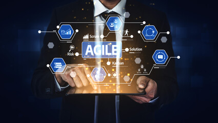 A businessman interacts with a tablet displaying agile project management icons. The image represents modern technology and teamwork in a professional environment. Tessel