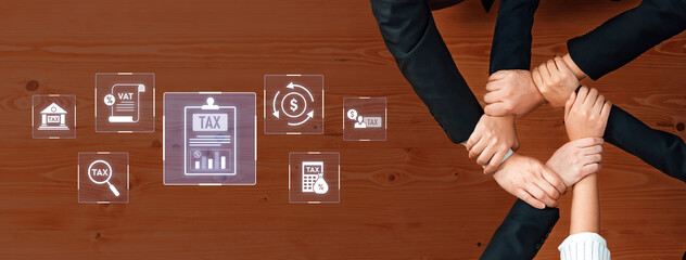 Diverse hands collaborate over a wooden table, with digital tax icons illustrating finance...