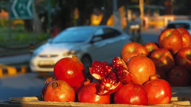 Street Vendor Selling Fresh Pomegranates Beside a Busy Road in India