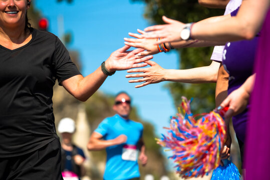 Hands of people cheering up marathon runners