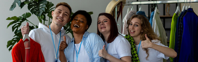 Banner. Group of volunteers, young women, man, sorting clothes in charitable foundation for charity donation, recycling. Concept of textile pollution, conscious consumption. Ecology, sustainable life
