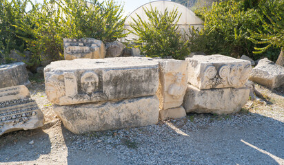 Intricate Ancient Stone Relief with Carved Faces in Demre, Turkey, Showcasing Lycian Artistic Mastery