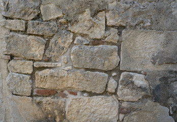 Background of weathered stone wall with ancient stonework.