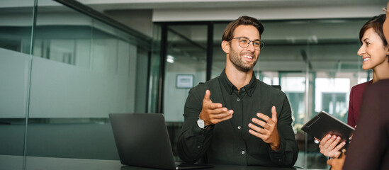 Obraz premium Young real estate manager worker man talking with bank client in office. Business meeting busy of entrepreneur professional people discussing financial planning trade strategy. Web banner, copy space