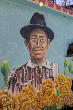 Mural painting of indigenous Mayan man in a hat on the side of a building in Santa Cruz la Laguna, Solola, Lake Atitlan, Guatemala.