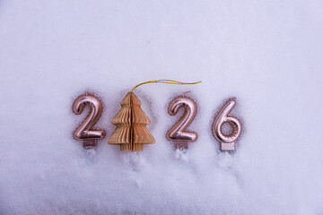 New Year 2026 written on snow with a paper Christmas tree ornament replacing zero and copy space for text.