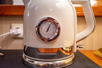 Modern white electric kettle with round analog temperature gauge