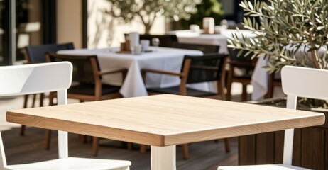 Obraz premium Modern outdoor dining table with white chairs and olive tree