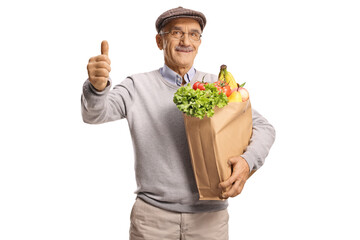 An elderly man with a bag of groceries gesturing thumbs up