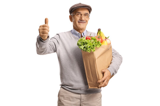 An elderly man with a bag of groceries gesturing thumbs up