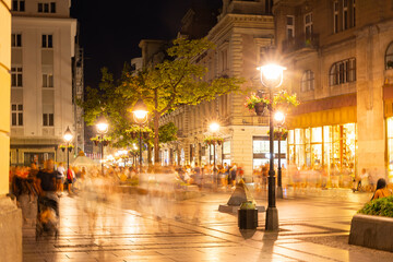 Warm summer evening on Knez Mihailova Street in Belgrade, with glowing lanterns, historic facades, and lively crowd of locals and tourists in motion