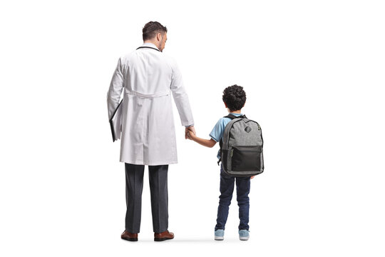 Doctor standing and holding hands with a schoolboy