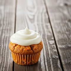 Freshly baked delicious carrot muffins topped with creamy white frosting arranged attractively on a rustic brown wooden table surface, arrangement, baked, snack