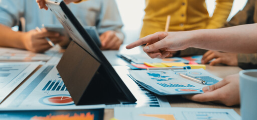 A dynamic office scene showcasing a diverse group of professionals engaged in a collaborative meeting. Focused on charts, reports, and digital devices for effective data analysis. SACTR