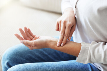 Woman checking her pulse with fingers indoors, closeup