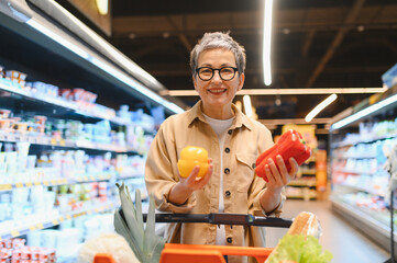 Mature woman smiling while grocery shopping for healthy food